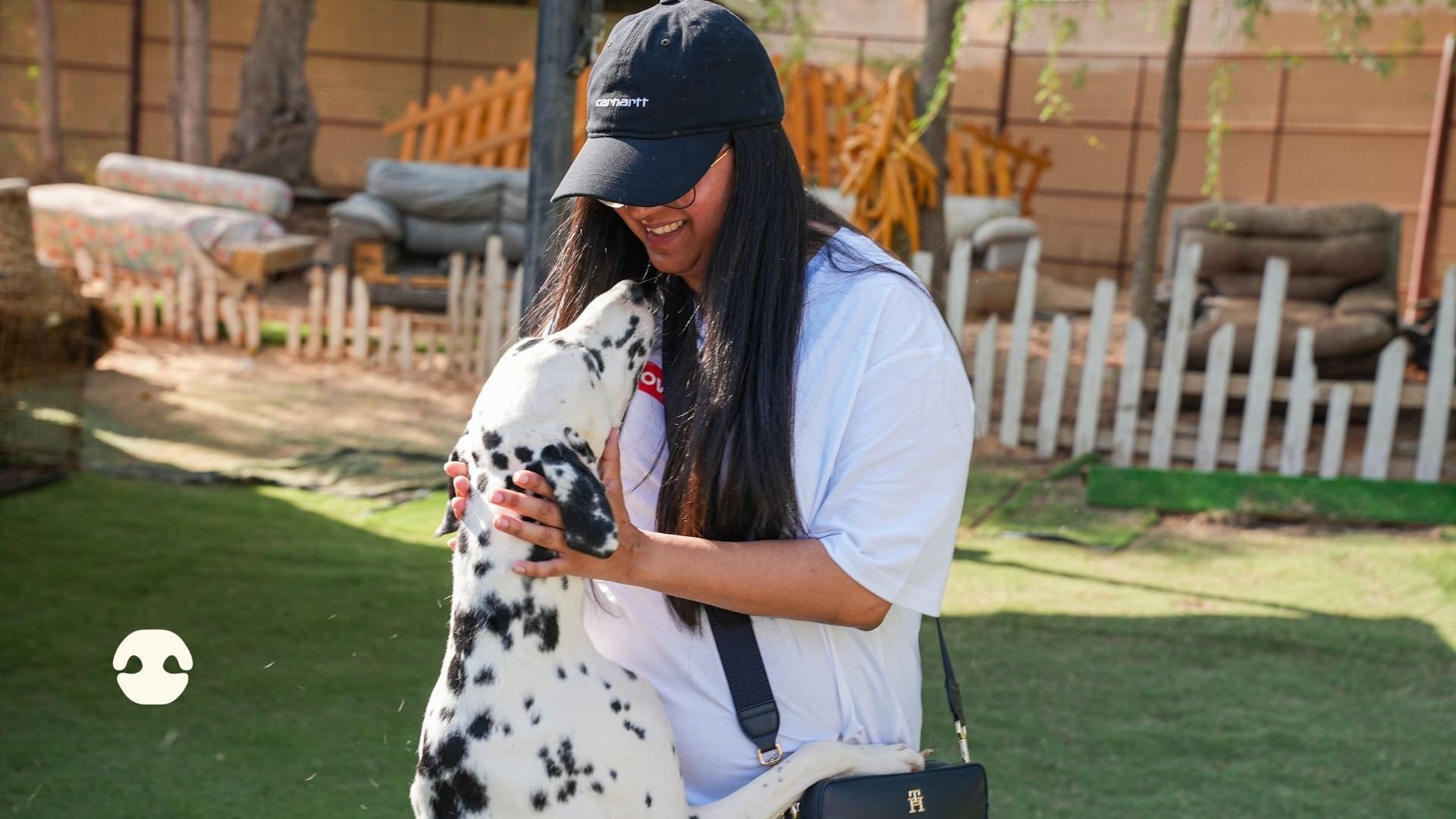 Lenovo Foundation volunteer smiling as a Dalmatian stands on its hind legs to cuddle her during a rescue dog volunteering day at Haven of Hope in Dubai.